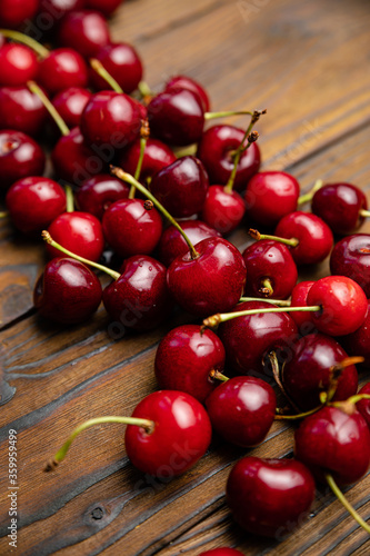 ripe, red, farm cherries on a brown wooden background
