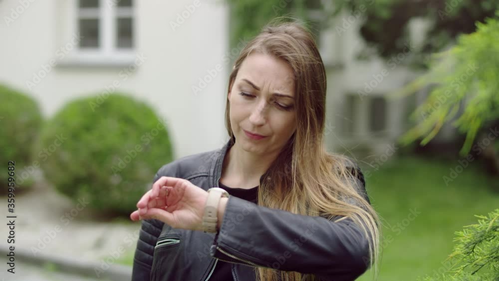Young and nervous woman is checking her watch while waiting for someone. Young and nervous woman is checking her watch while waiting for someone.