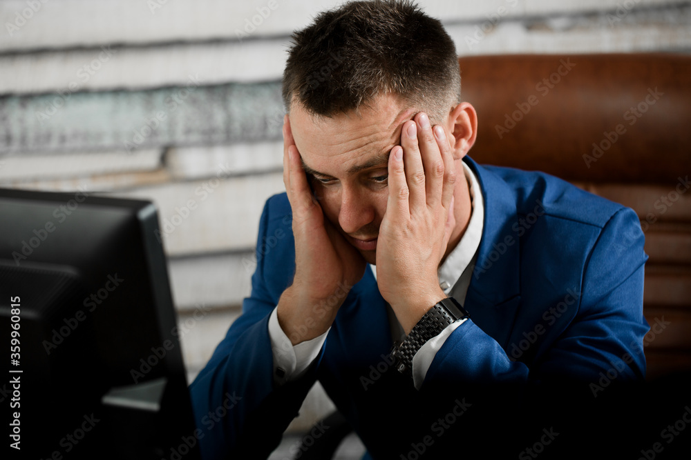 Tired business man at workplace in office holding his head on ha Tired business man at workplace in office holding his head on ha