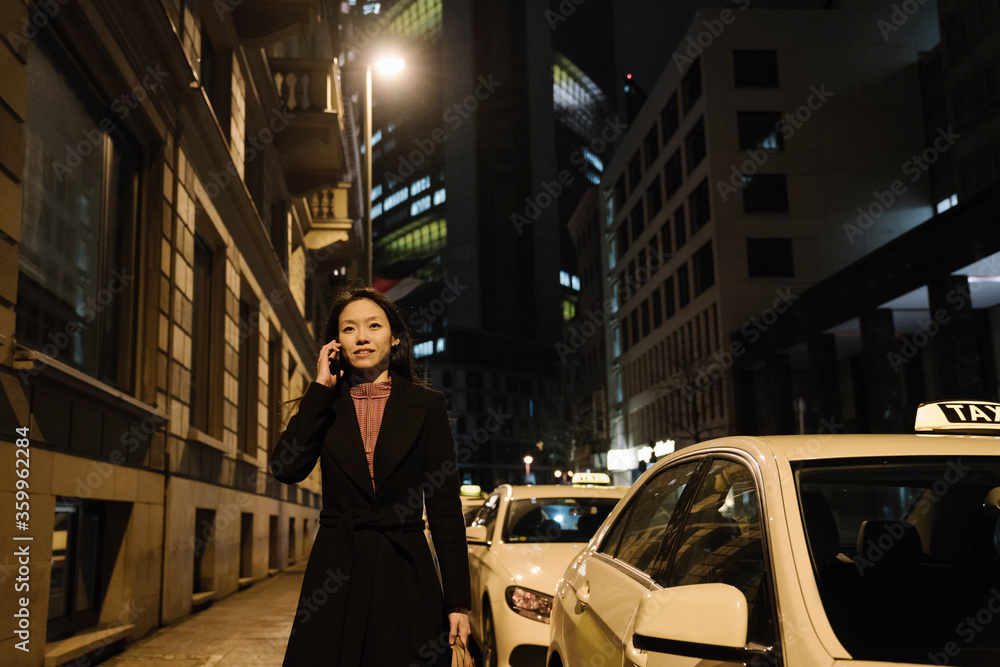 Young woman on the phone in the city at night, Frankfurt, Germany Young woman on the phone in the city at night, Frankfurt, Germany