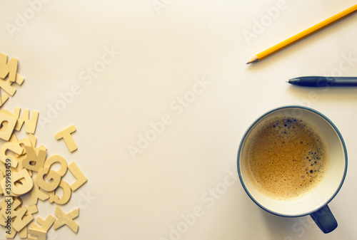 Schreibtisch mit Kaffeetasse, Buchstaben, Bleistift und Kugelschreiber