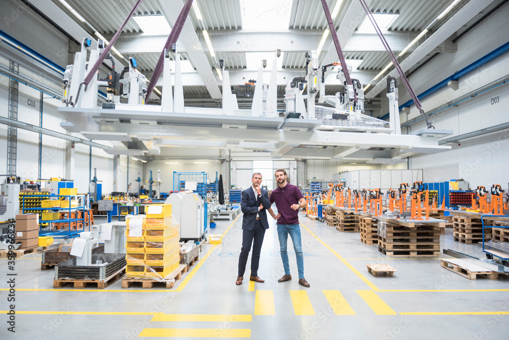 Two men with indoor crane in a factory Two men with indoor crane in a factory