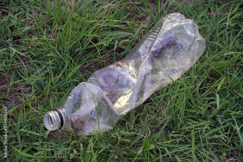 used plastic bottle as garbage on the grass, pollution concept © soleg