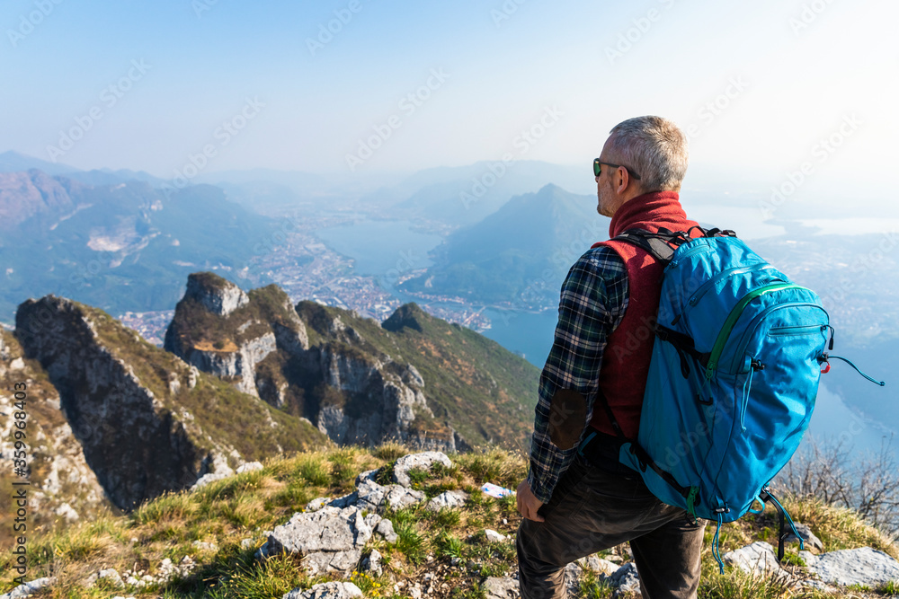 Rear view of hiker on mountaintop, Orobie Alps, Lecco, Italy Rear view of hiker on mountaintop, Orobie Alps, Lecco, Italy
