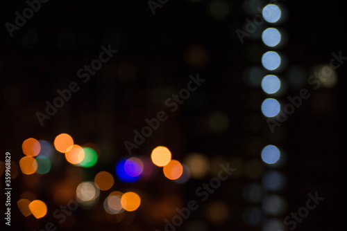 abstract unfocused picture of night city light colorful bokeh from lamps and lanterns, multi-colored spots on a dark background