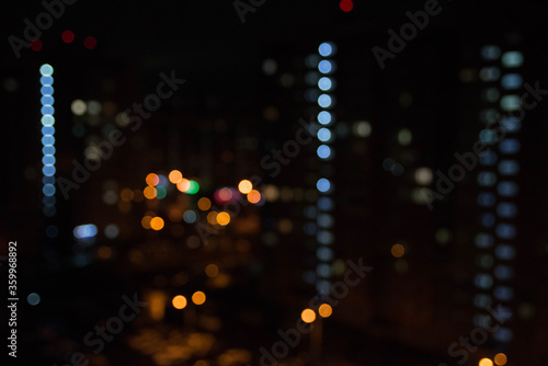 abstract unfocused picture of night city light colorful bokeh from lamps and lanterns, multi-colored spots on a dark background