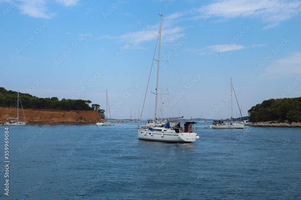 Vrgada/Croatia-June 21,st,2020: White yachts anchored in front of Vrgada island shore during tourist season at Croatian Adriatic coast