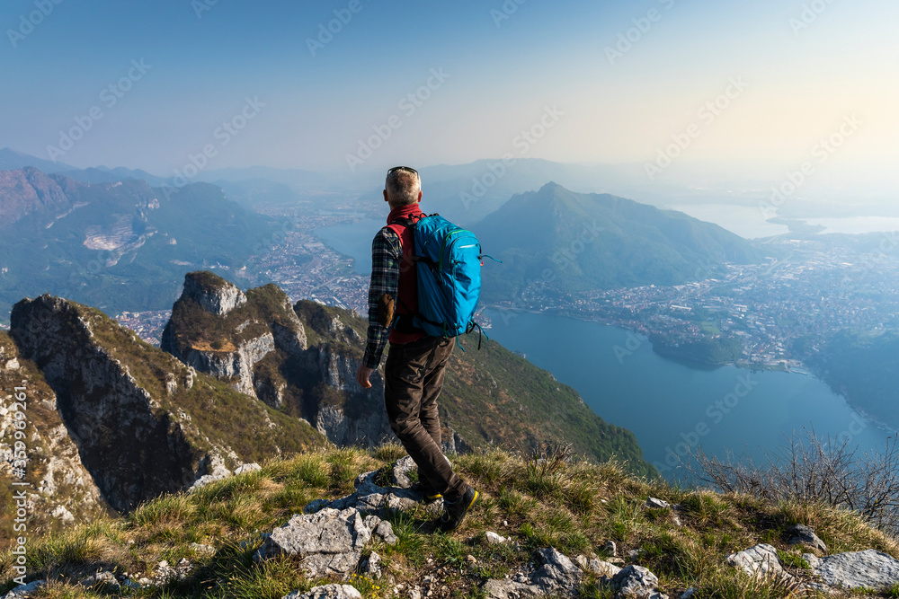 Rear view of hiker on mountaintop, Orobie Alps, Lecco, Italy