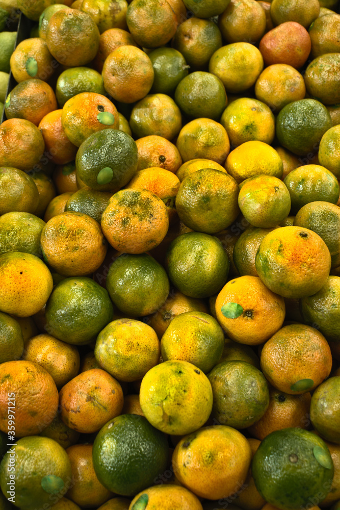 Unripe oranges on the market counter