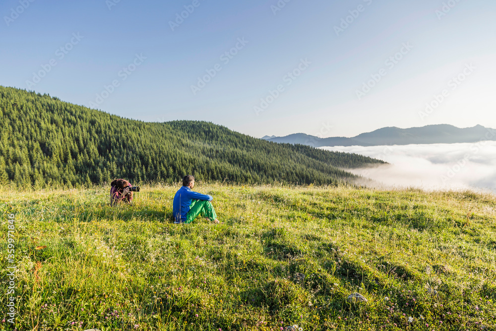 Man and woman with camera on a meadow in the mountains, Achenkirch, Austria Man and woman with camera on a meadow in the mountains, Achenkirch, Austria