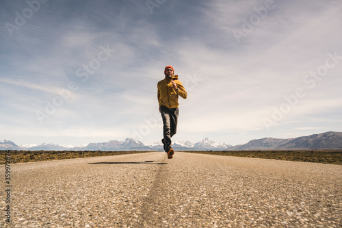 Man running on a road in remote landscape in Patagonia, Argentina photo