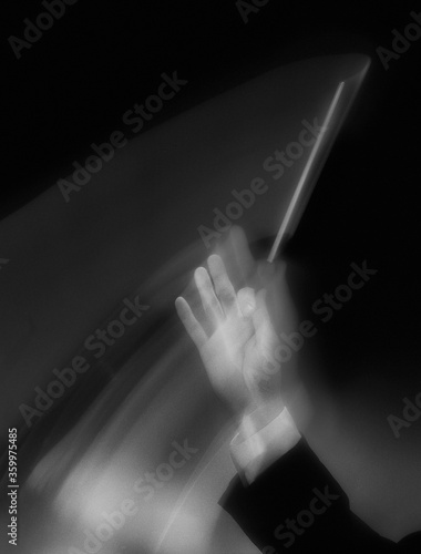 musical conductors hand holding baton in motion