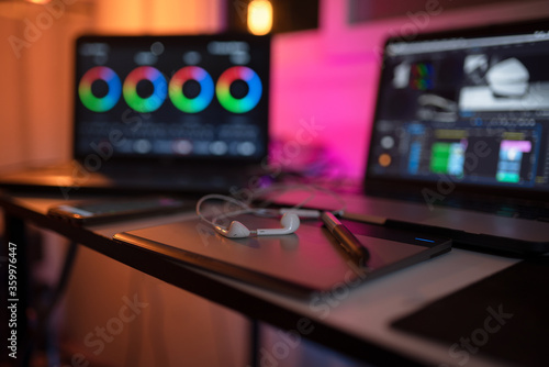 Headphone on the desk content creator and display color grading correction of editor freelance photo