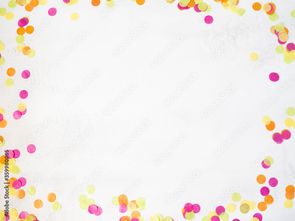 Colorful paper confetti scattered on a white background. Top view Colorful paper confetti scattered on a white background. Top view