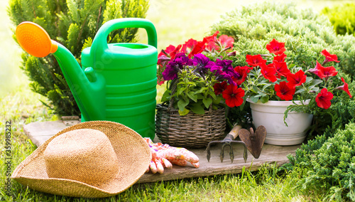 Gardening tools and straw hat on the grass in the garden