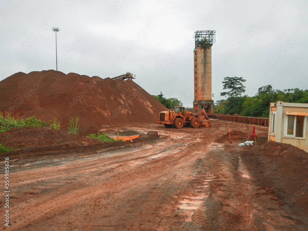 Mine Site in Yekepa, Liberia, 10 of June 2015. West Africa. Iron Ore Mining operator loads train which goes to Buchanan. Big Mining operator provides iron ore extraction and jobs for Yekepa people. Mine Site in Yekepa, Liberia, 10 of June 2015. West Africa. Iron Ore Mining operator loads train which goes to Buchanan. Big Mining operator provides iron ore extraction and jobs for Yekepa people.