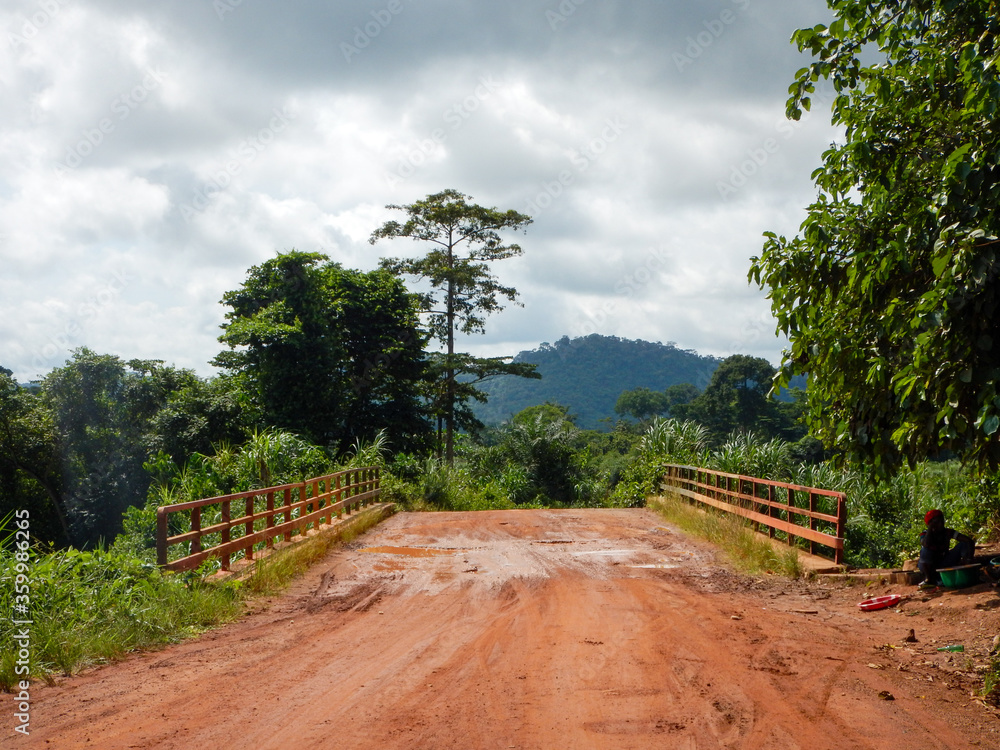 West Africa, Liberia, 6 of July 2015. Road to Yekepa between villages, in the middle of the bush, dangerous bridge. Unpaved road conditions. West Africa, Liberia, 6 of July 2015. Road to Yekepa between villages, in the middle of the bush, dangerous bridge. Unpaved road conditions.