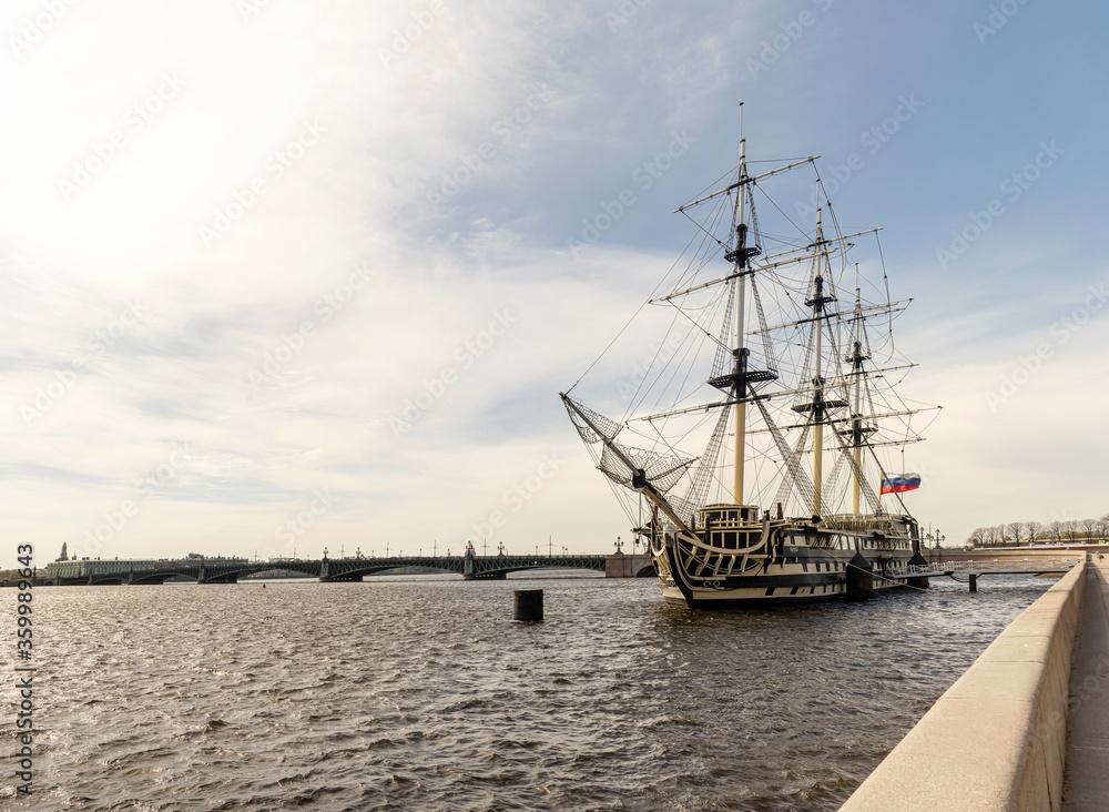 An old sailing frigate on the Neva river in Saint Petersburg,  Russia. An old ship is parked on the embankment of the Neva river.