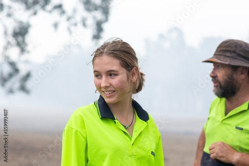 Two workers wearing hi-vis with smoky background photo