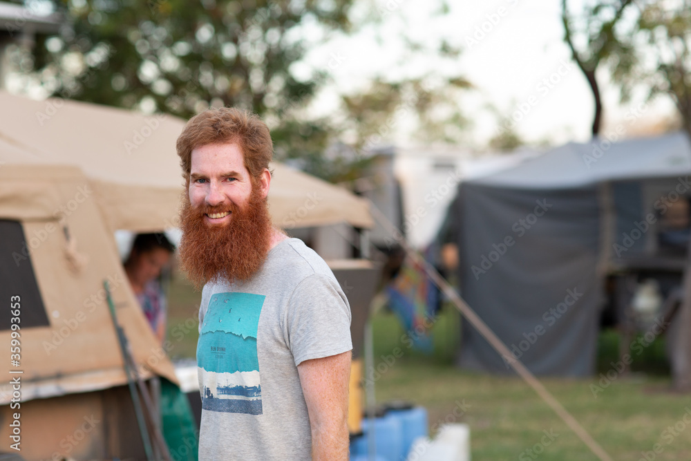 Bearded man near camper trailer in campground Bearded man near camper trailer in campground