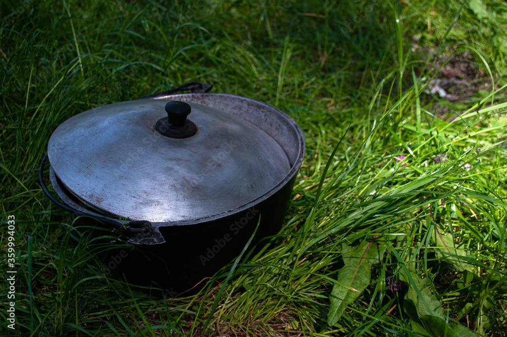 Big cauldron on the grass. Food preparation in forest. Big cauldron on the grass. Food preparation in forest.