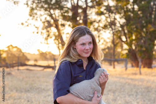 Farm girl holding a little lamb