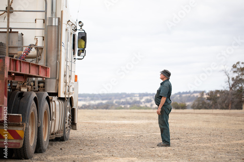 portly fellow looking up to talk to a truck driver