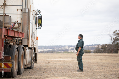 portly fellow looking up to talk to a truck driver photo
