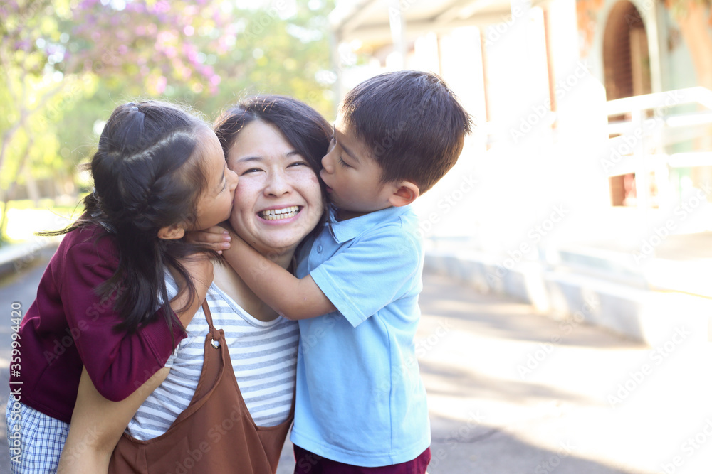 Young girl and boy in school uniform, hugging their mother. Young girl and boy in school uniform, hugging their mother.