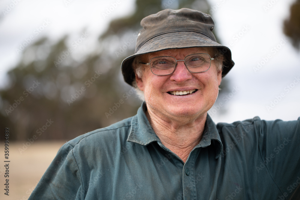 smiling old man wearing glasses and grubby bucket hat smiling old man wearing glasses and grubby bucket hat