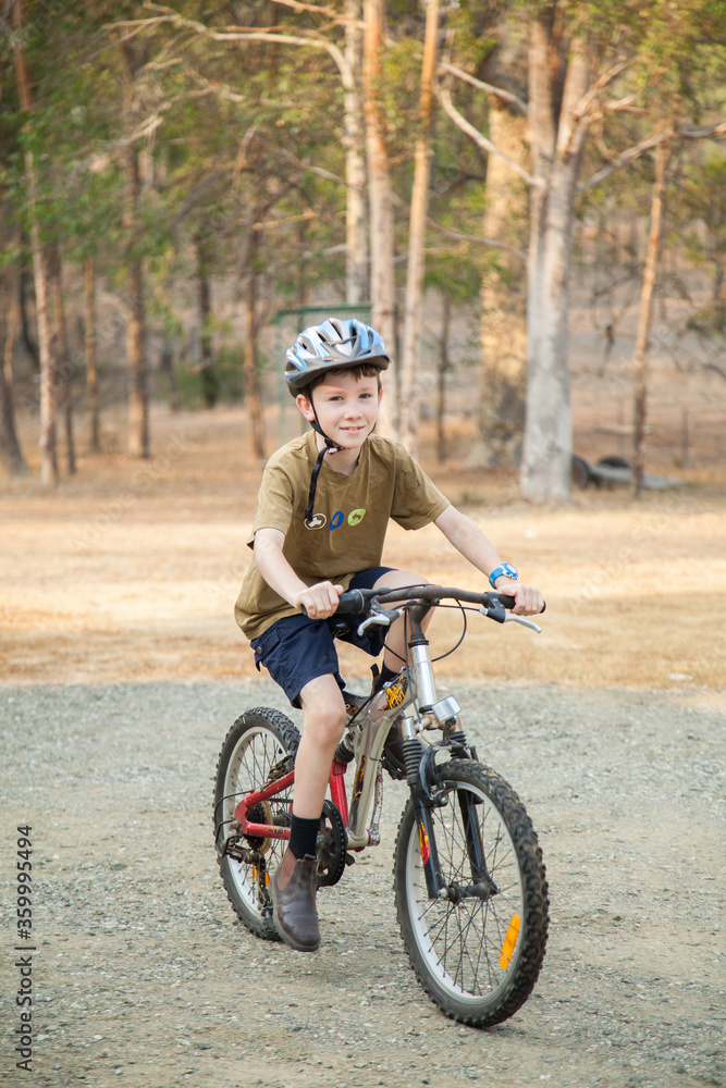 Nine year old boy riding pushbike with helmet and boots on Nine year old boy riding pushbike with helmet and boots on