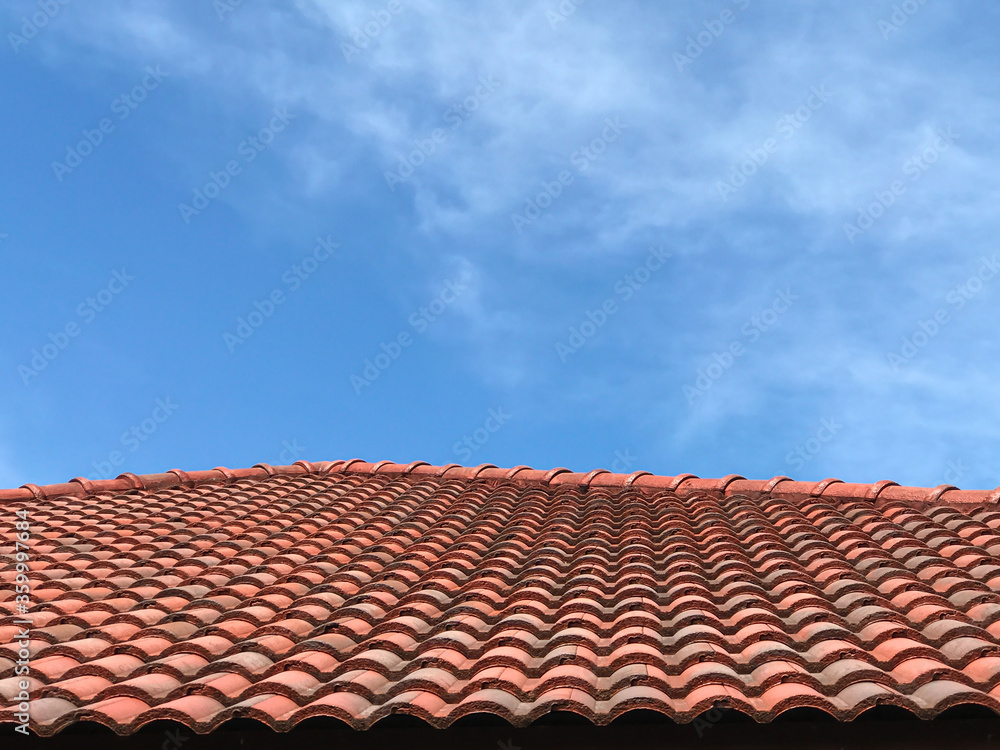 Red burgundy roof tiles on blue sky. Red burgundy roof tiles on blue sky.