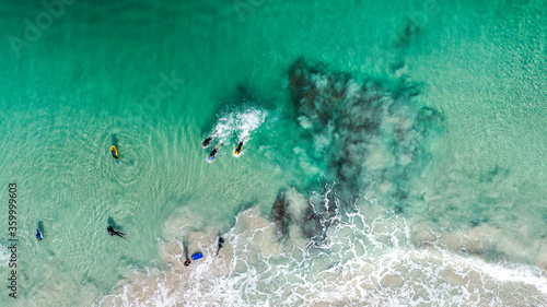 An aerial view of bodyboarders paddling for position photo