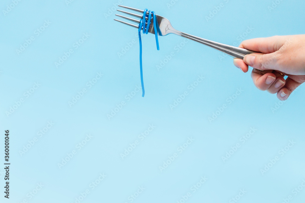 wires wound around a fork on a blue background