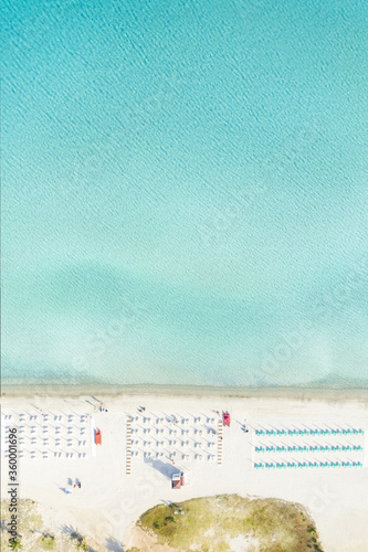 View from above, stunning aerial view of a white sand beach with beach umbrellas and a beautiful turquoise sea. Marinella Beach, Porto Rotondo,Sardinia, Italy.