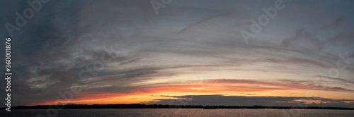 Tableau sur toile Colorful Sunny sunset over a navigable calm river. Panorama