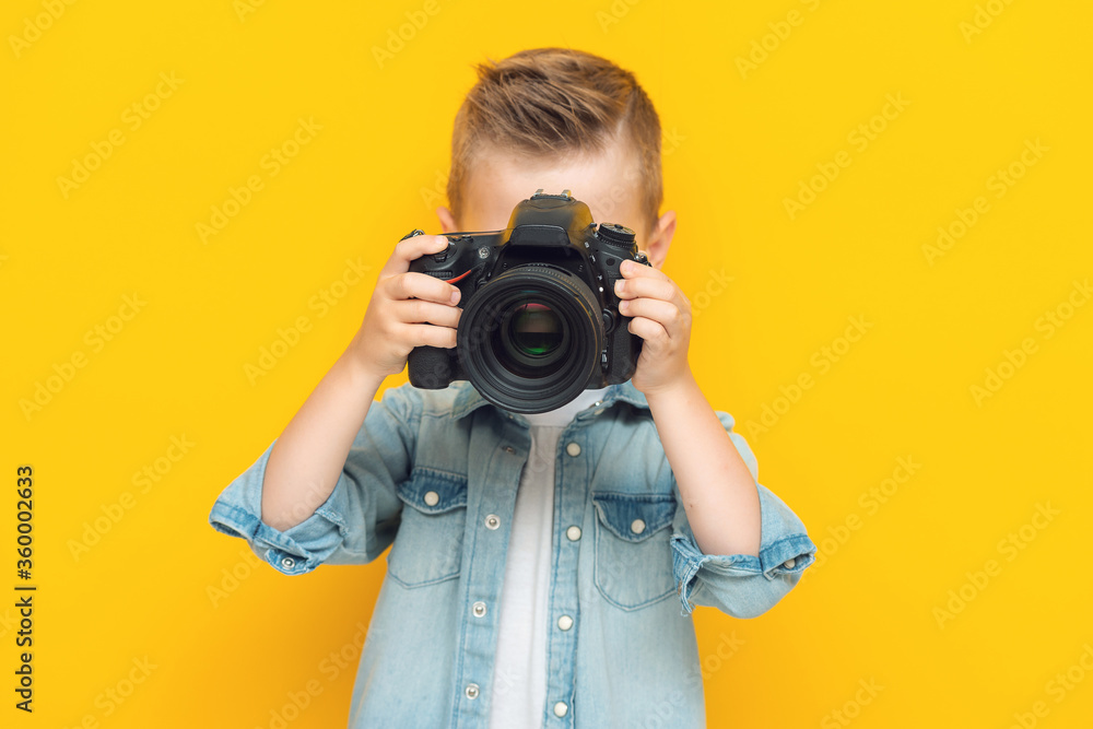 Adorable little kid taking a photo using a digital camera Adorable little kid taking a photo using a digital camera