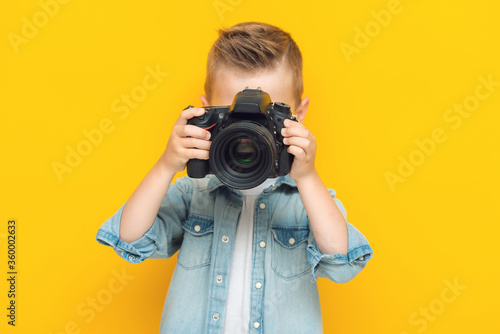 Adorable little kid taking a photo using a digital camera