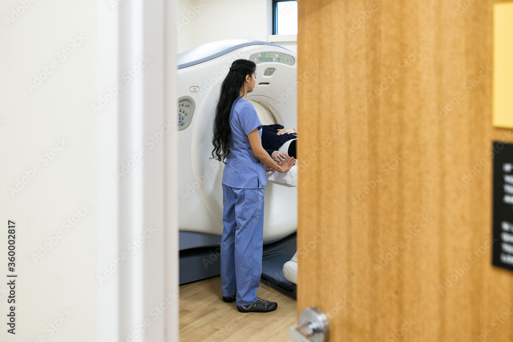 Clinic: Nurse Inside CT Scan Room With Patient Clinic: Nurse Inside CT Scan Room With Patient