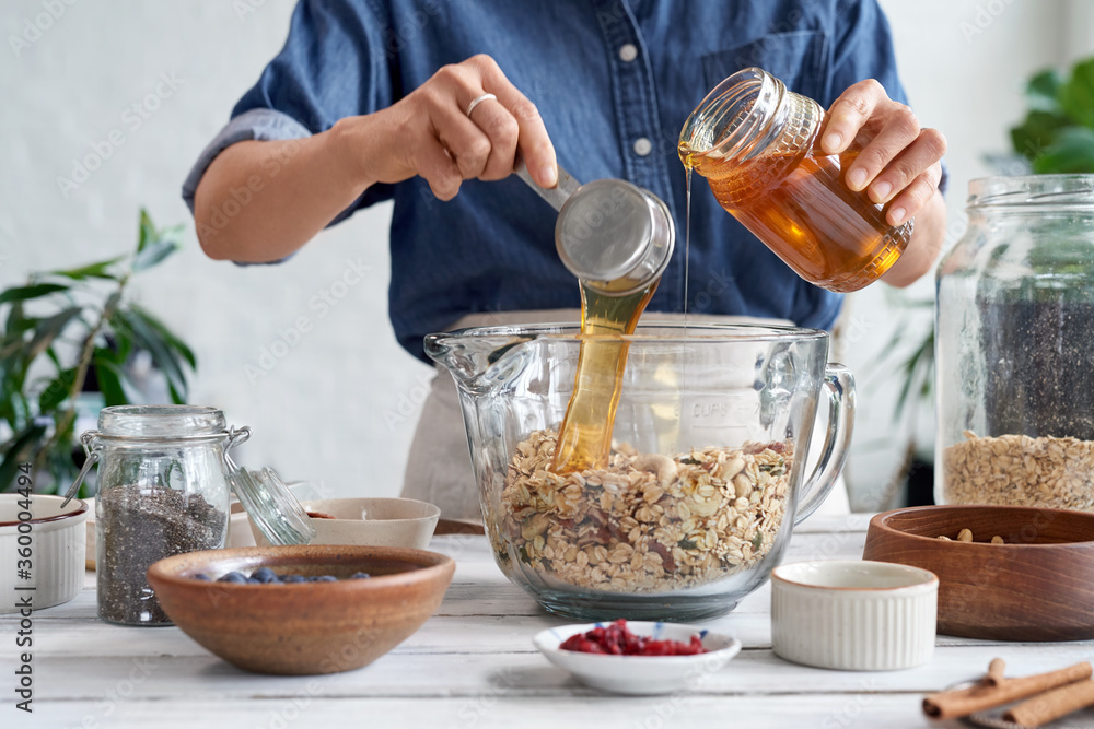 Woman at home making homemade granola Woman at home making homemade granola