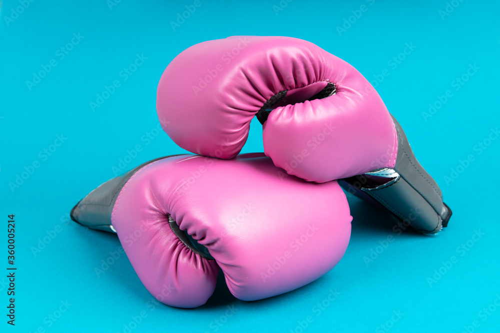 Pair of pink boxing gloves on blue background