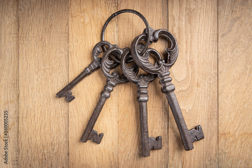 Bunch of old keys on wooden background © dechevm