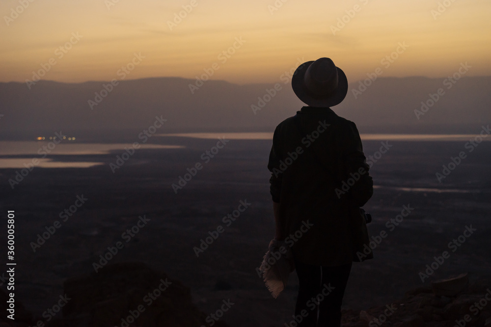 Anonymous woman admiring view during sunset