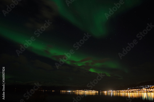 strong vibrant aurora borealis, northern light in autumn night in the arctic circle