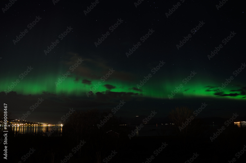 vibrant aurora borealis over silent fjord and mountain landscape