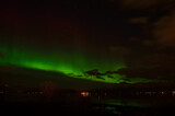 aurora borealis on autumn night sky over fjord and settlement in the arctic circle