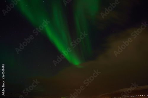 Vivid green aurora borealis  northern light on late autumn night sky