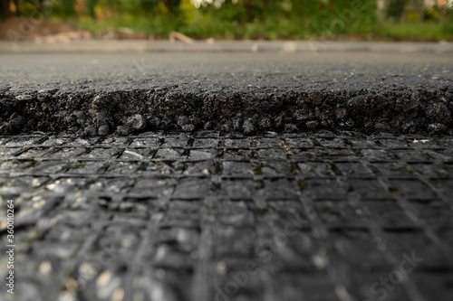 A large layer of fresh hot asphalt. Layer of asphalt raw material in a shallow dept of field.