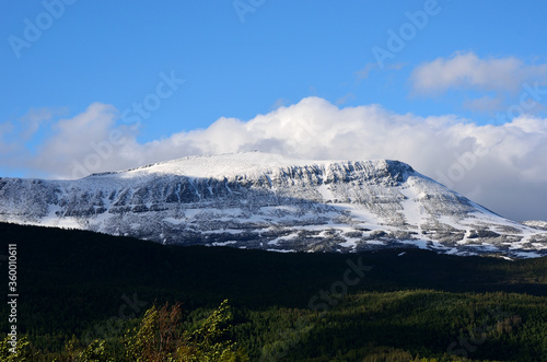 snowy mountain and blue summer sky
