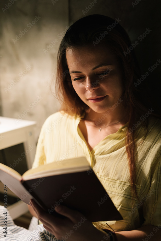 Young woman reading a book in bed Young woman reading a book in bed